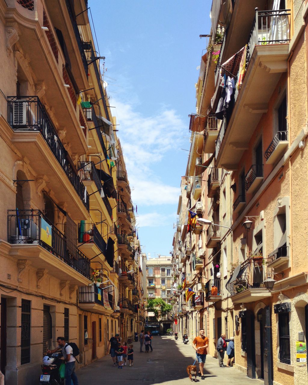 PEOPLE WALKING ON STREET AMIDST BUILDINGS IN CITY