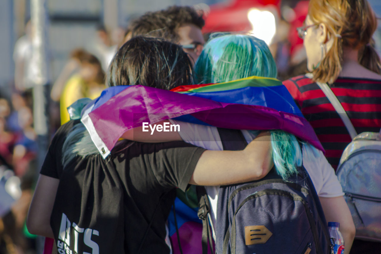 Rear view of friends standing during gay pride parade