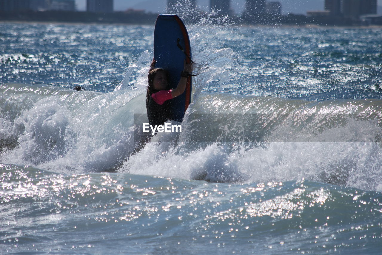 Young woman surfing in sea