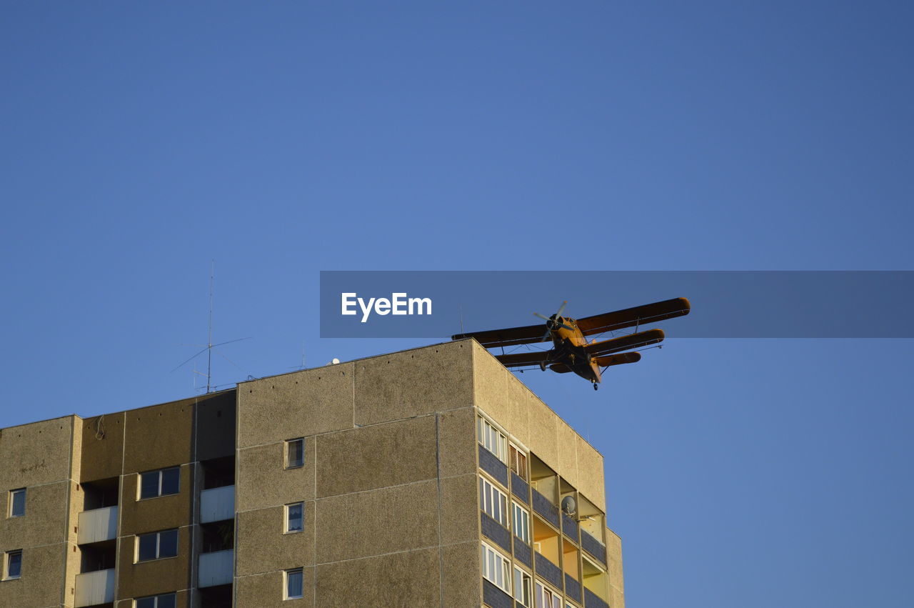 Low angle view of airplane above built structure