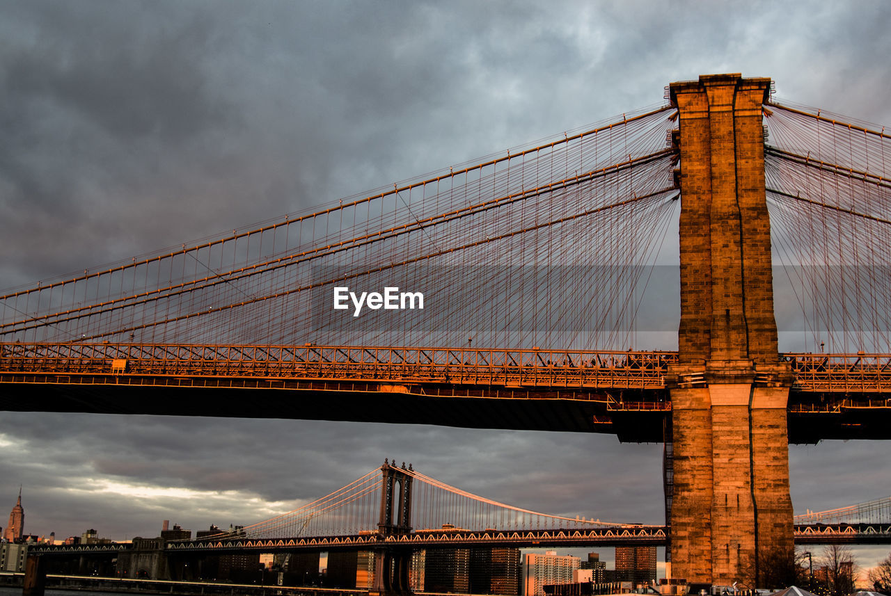 Brooklyn and manhattan bridges against cloudy sky
