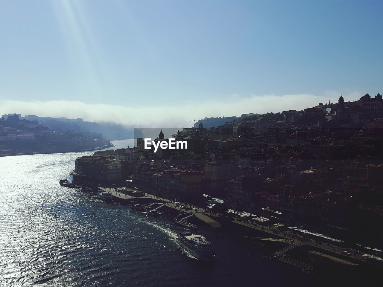 Aerial view of city by sea against sky