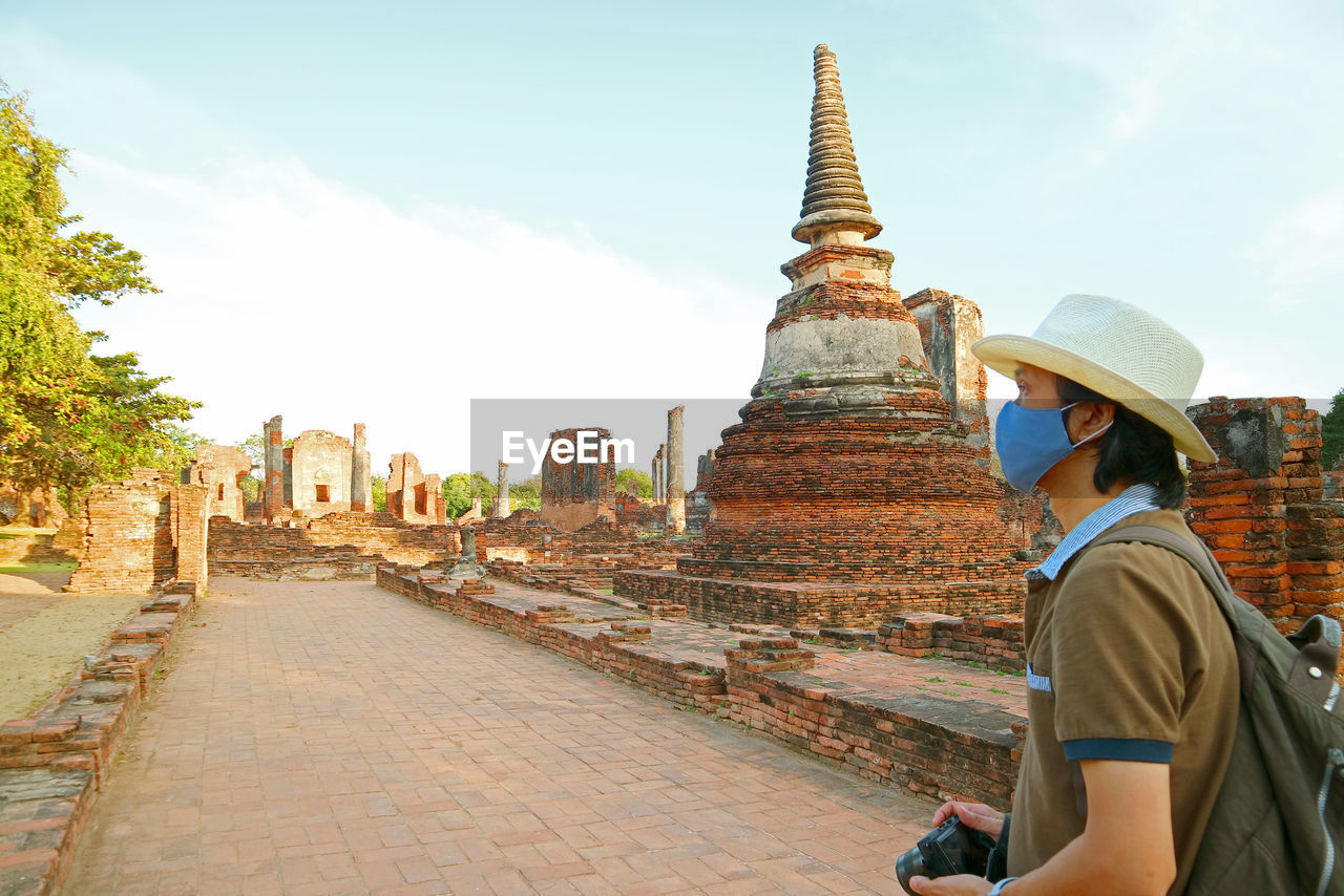 Visitor wearing face mask during a visit to wat phra si sanphet amid covid-19, ayutthaya, thailand