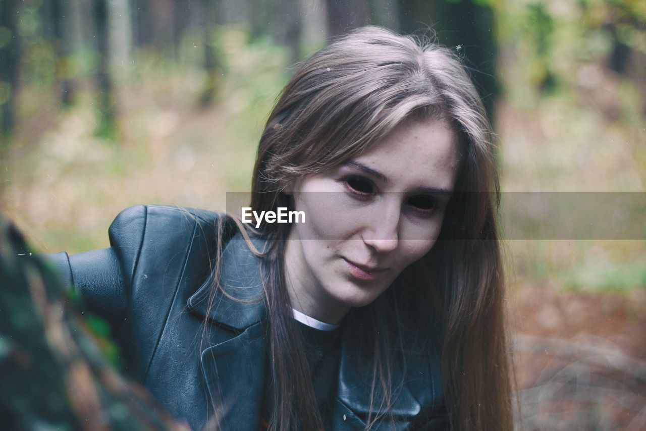 Close-up of woman with spooky eyes in forest