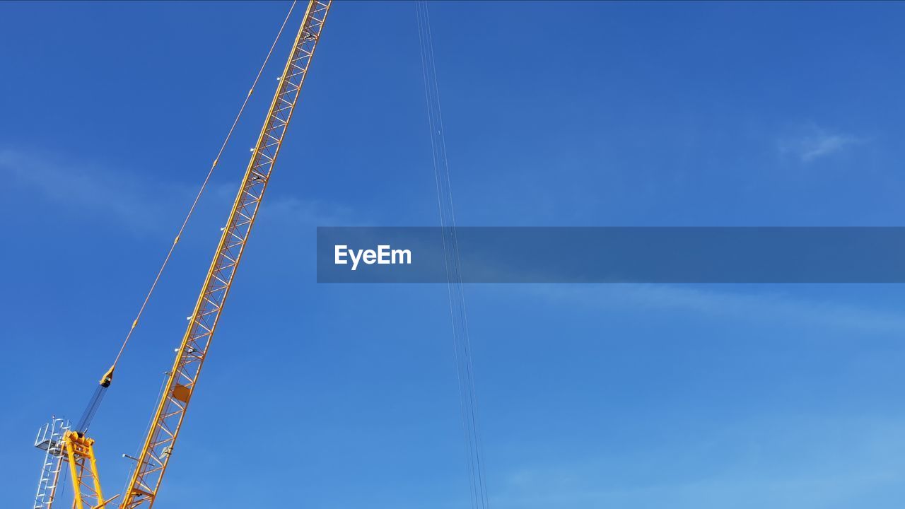 LOW ANGLE VIEW OF CRANES AGAINST SKY