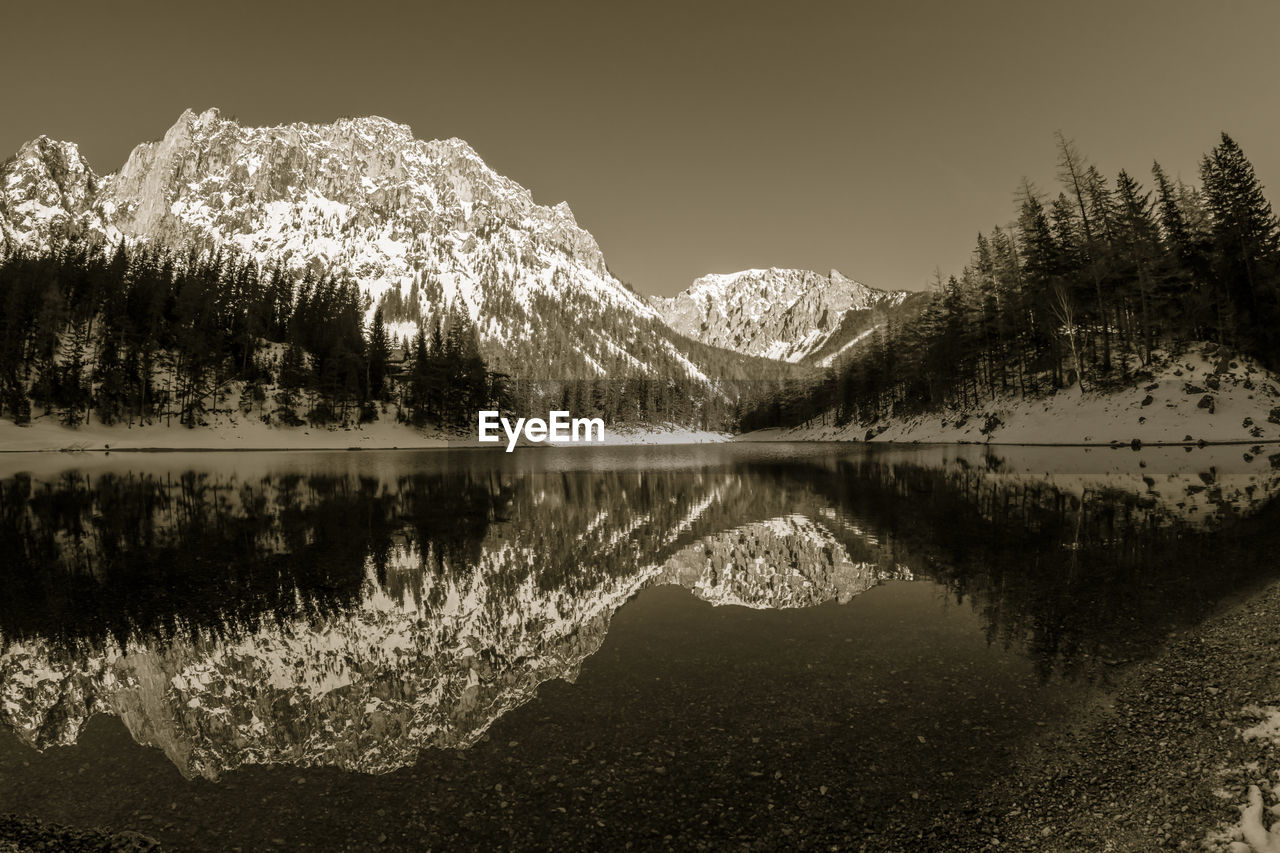 Scenic view of lake by trees against sky