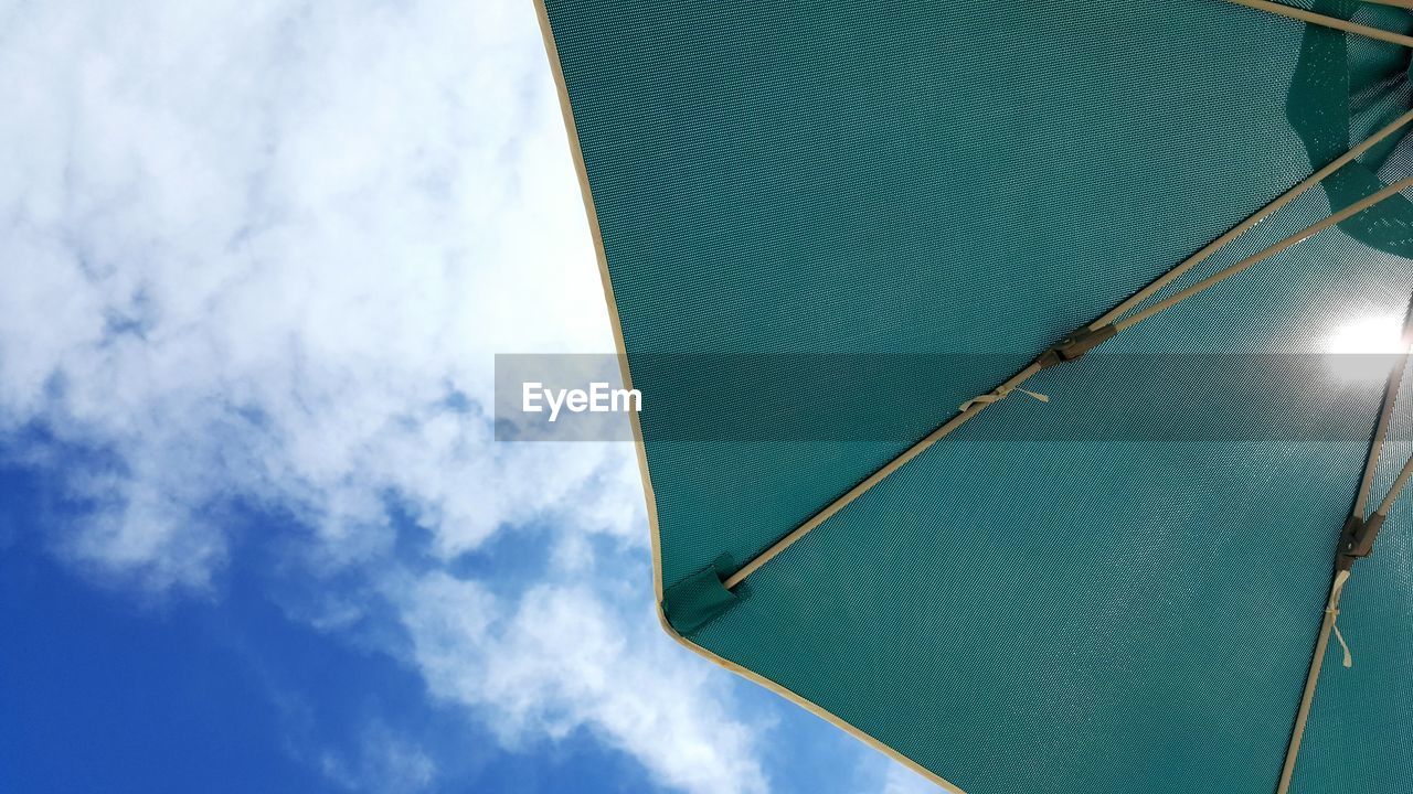 Directly below shot of beach umbrella against cloudy sky