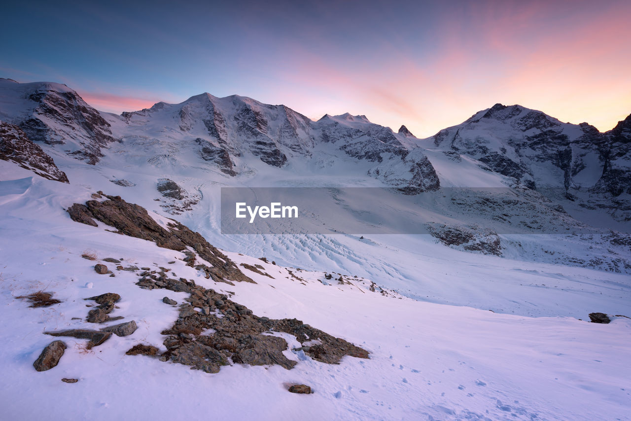 Scenic view of snowcapped mountains against sky during sunset