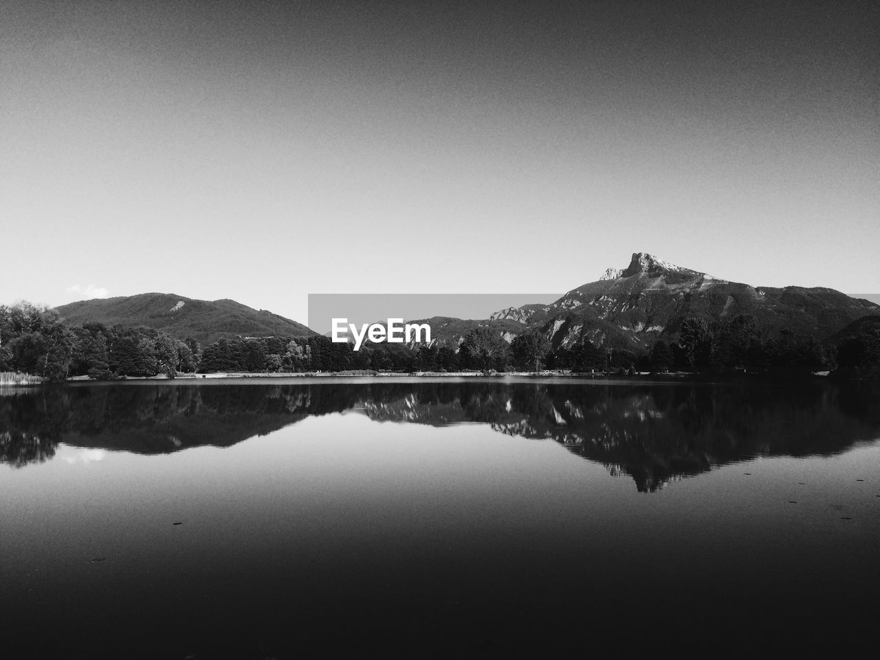 Reflection of trees and mountains in calm lake