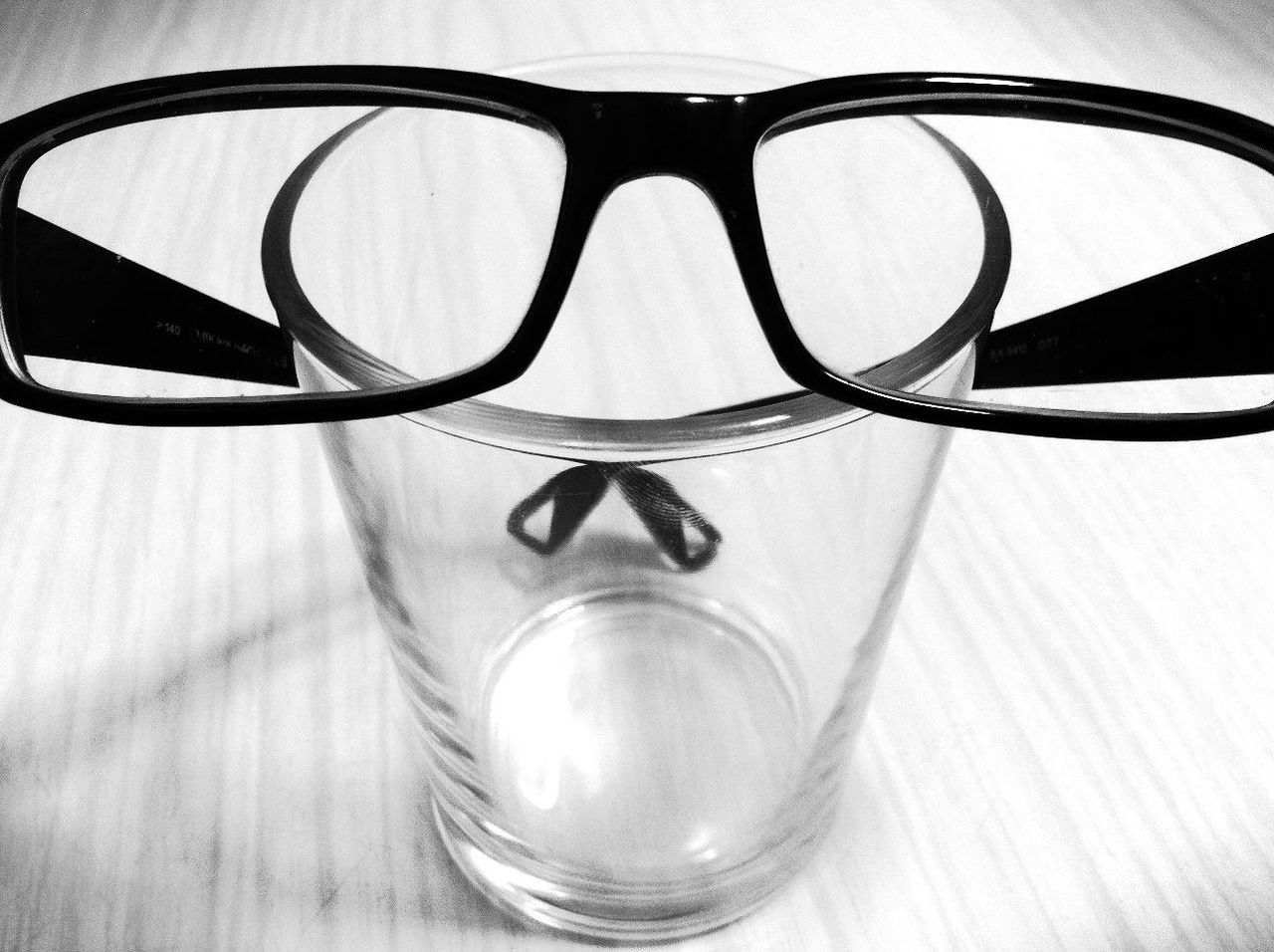 CLOSE-UP OF EYEGLASSES ON GLASS