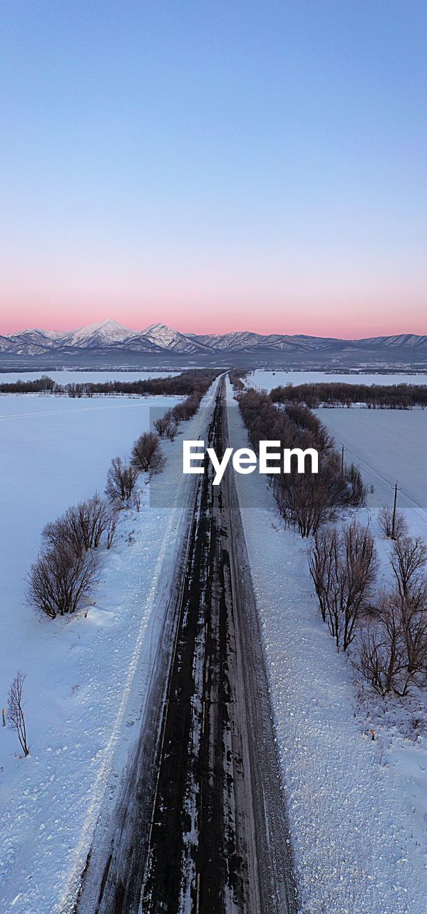 Panoramic view of frozen lake against clear sky during winter