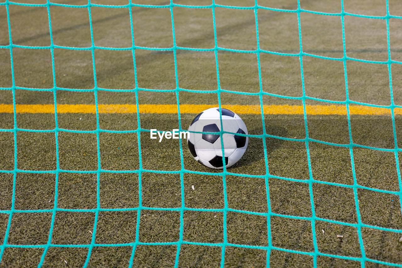 Soccer ball inside the goal as seen from behind the net