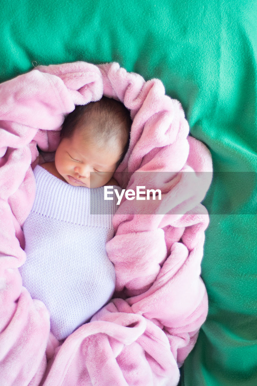 Close-up of baby girl sleeping on bed