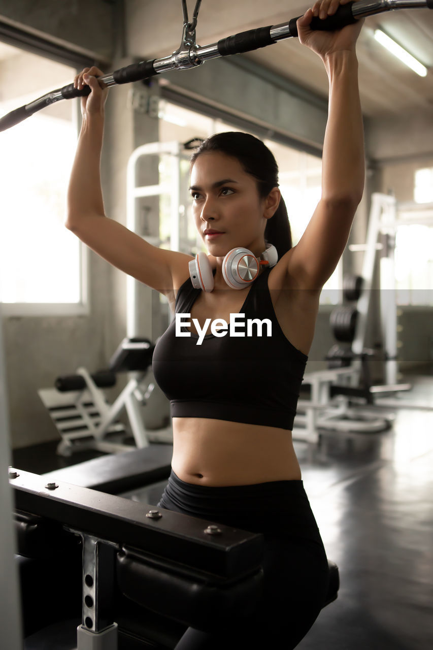 Woman with arms raised exercising in gym