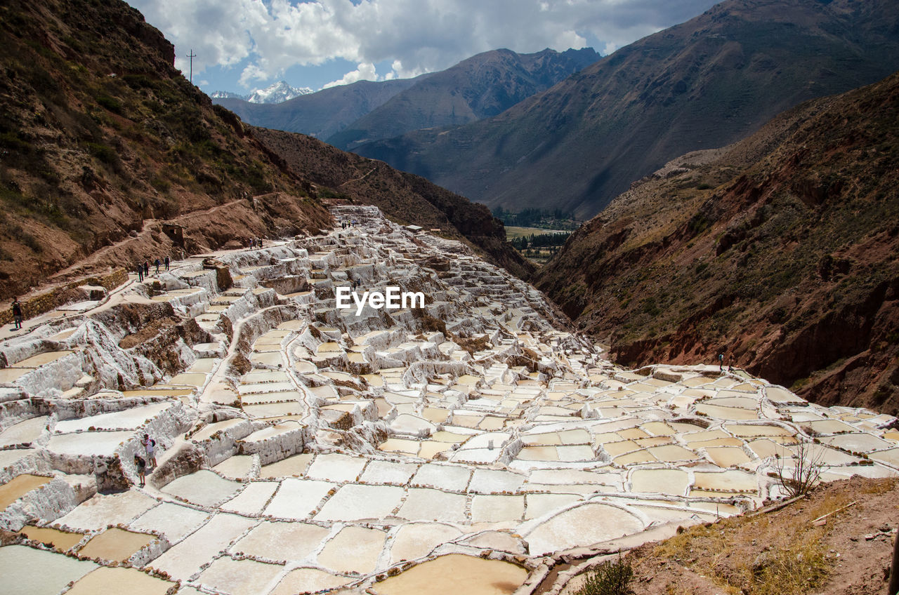 High angle view of salt pans against rocky mountains