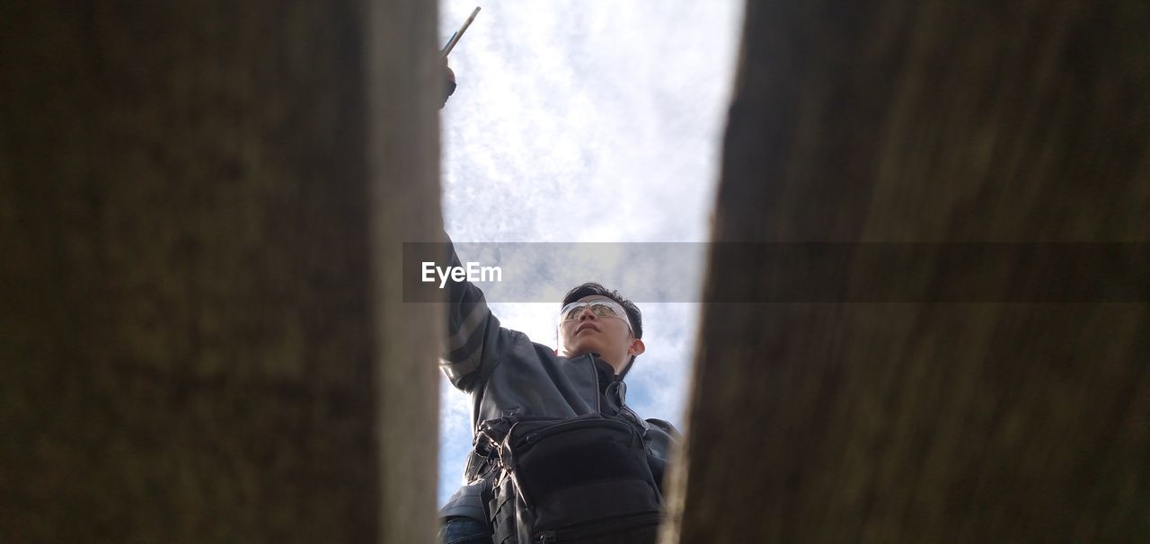 Low angle view of man standing against sky