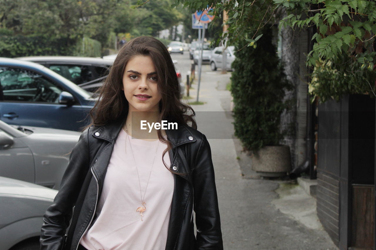 Portrait of a young teenage girl with long hair on the street