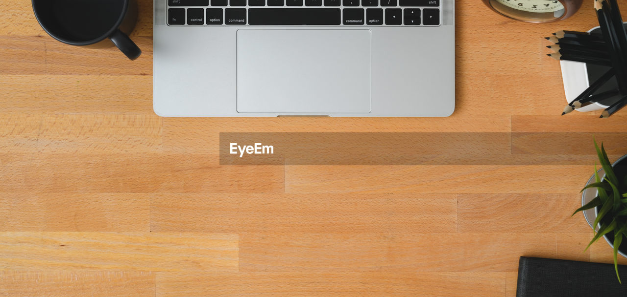 HIGH ANGLE VIEW OF LAPTOP ON WOODEN TABLE