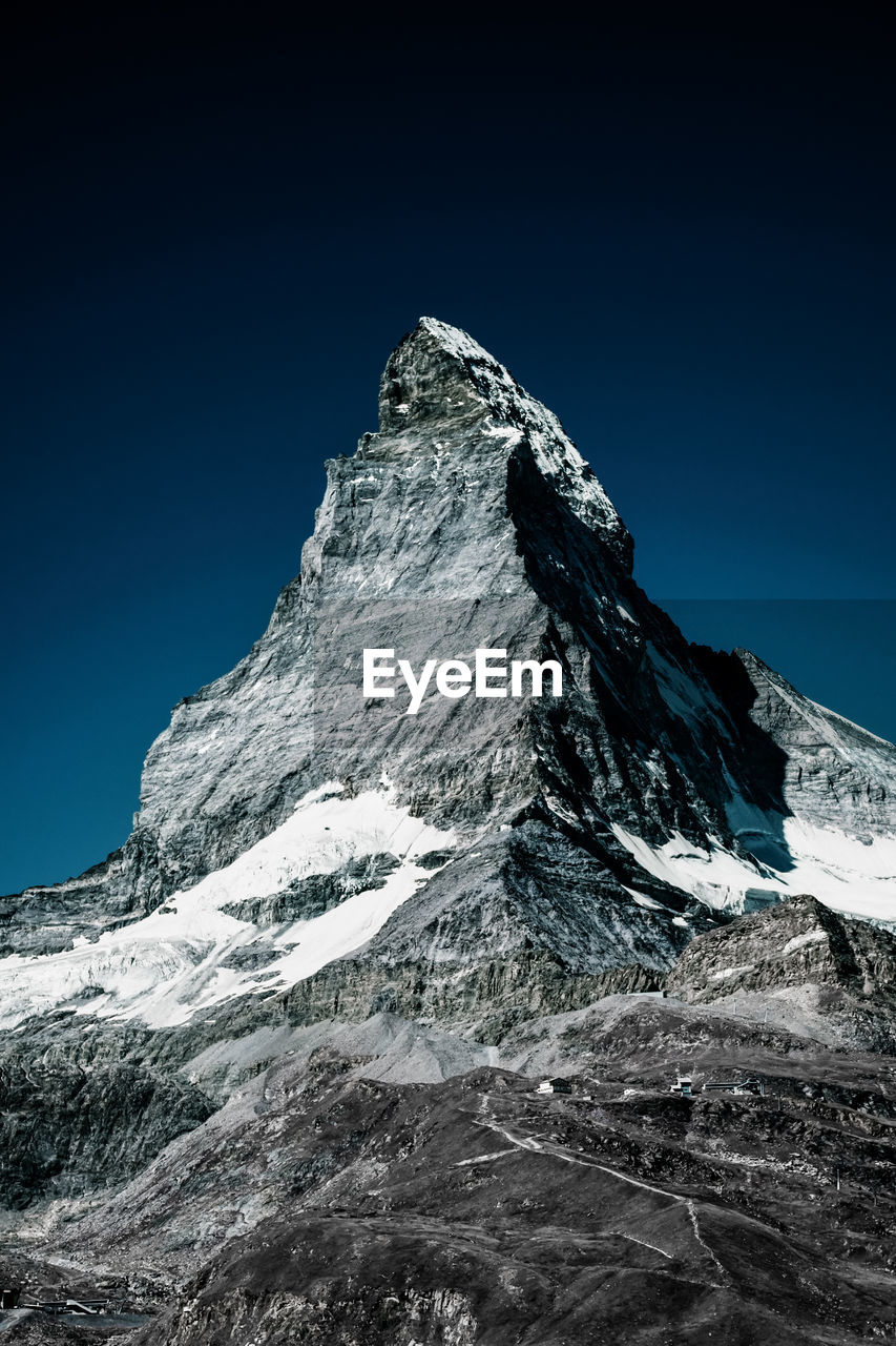 Low angle view of matterhorn mountain against clear blue sky