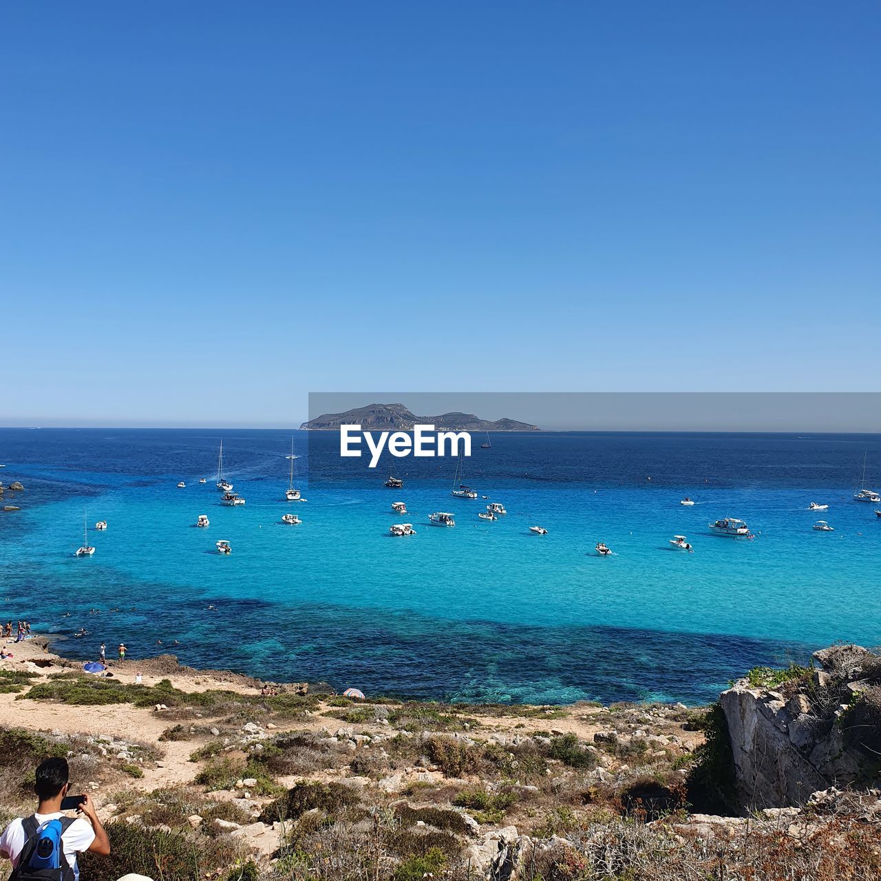 PEOPLE ON BEACH AGAINST CLEAR BLUE SKY