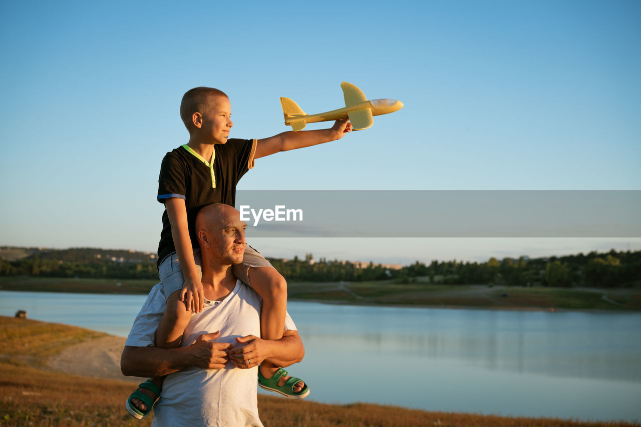 Dad and son in nature with an airplane