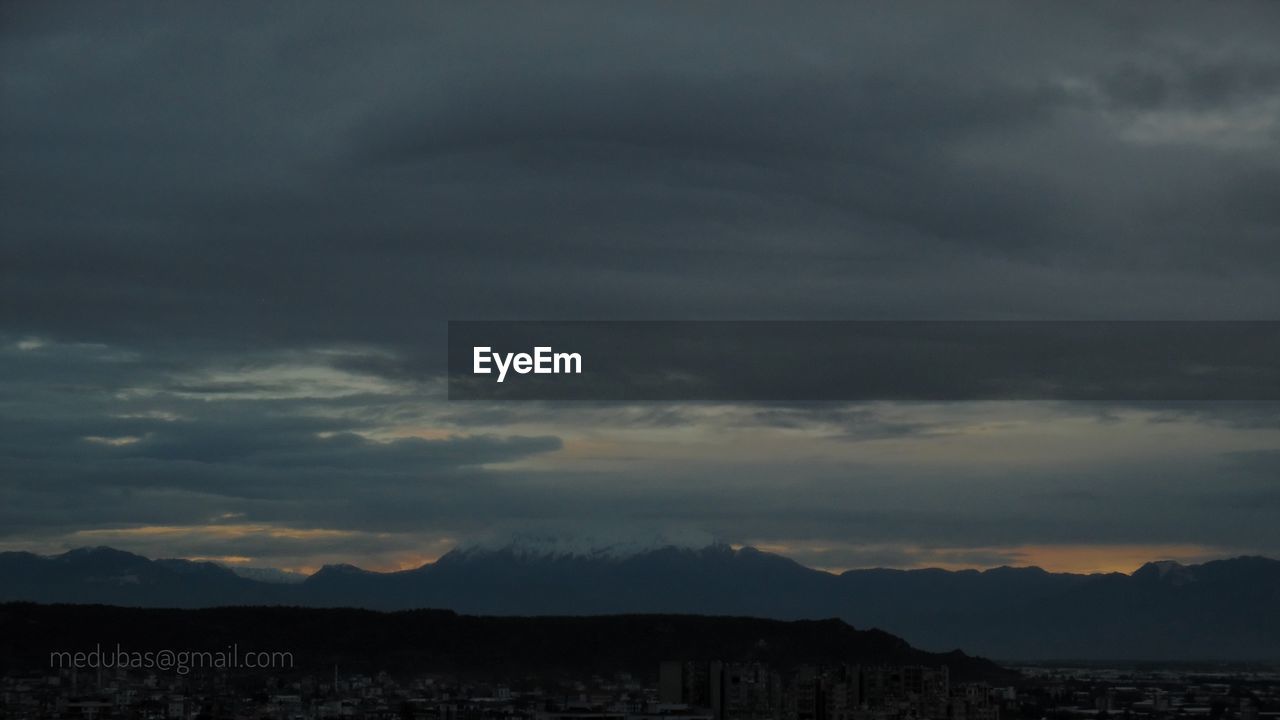 SCENIC VIEW OF DRAMATIC SKY OVER SILHOUETTE MOUNTAINS