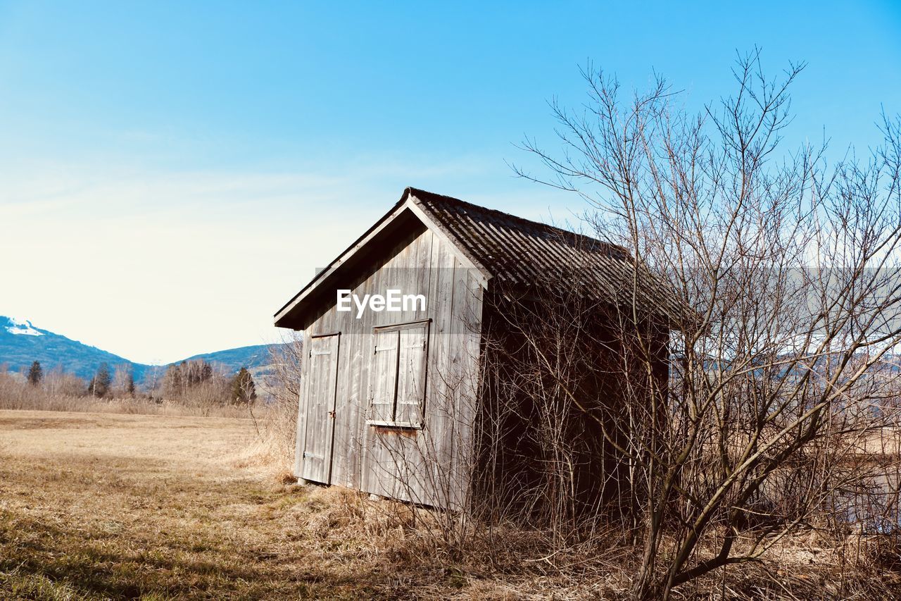 Abandoned house on field against sky