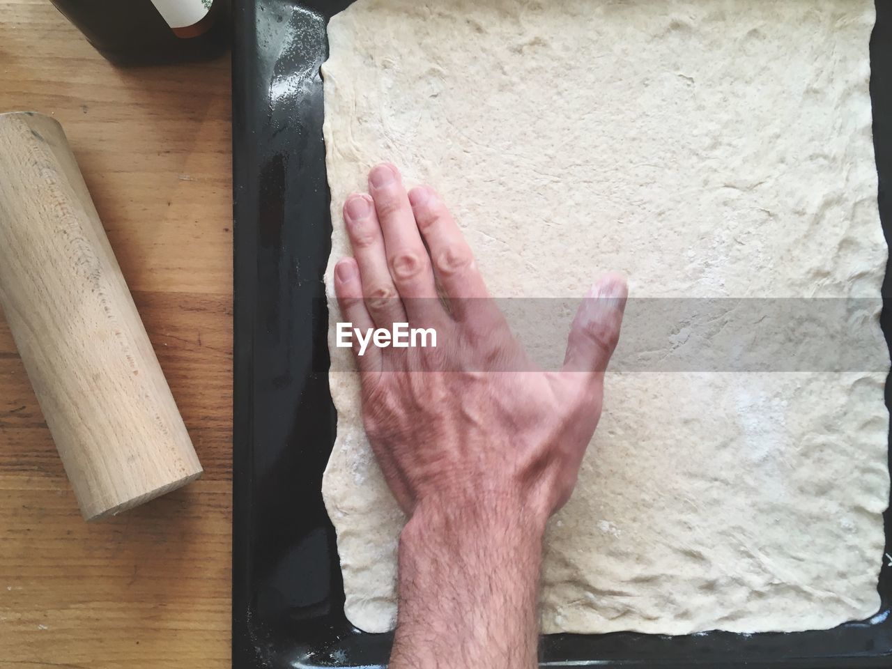 Cropped hand of man preparing food in kitchen