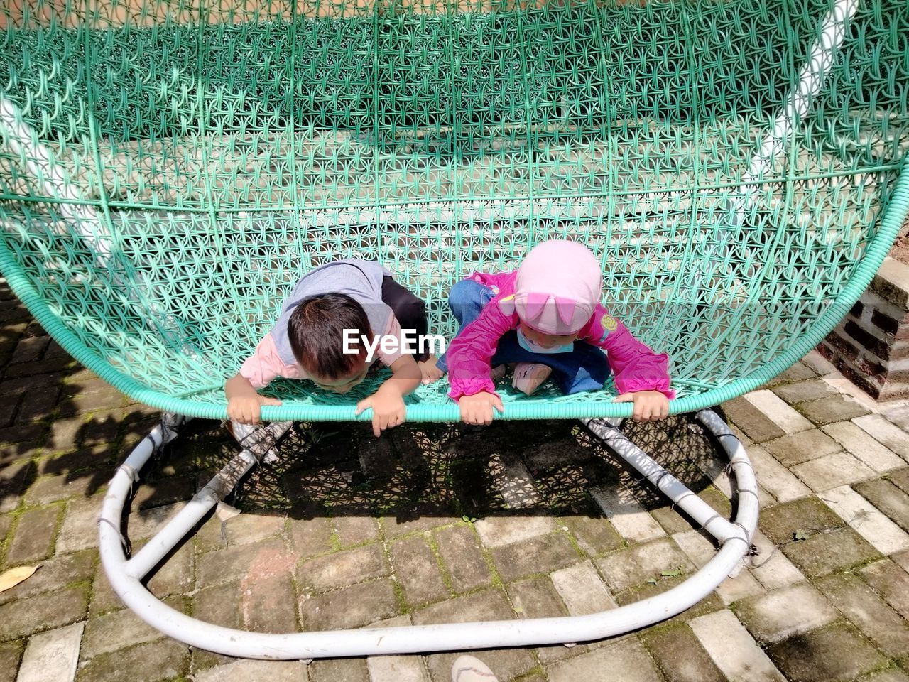 Boy and girl wearing hat on floor