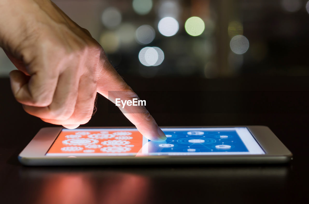 Cropped hands of man using digital tablet on table