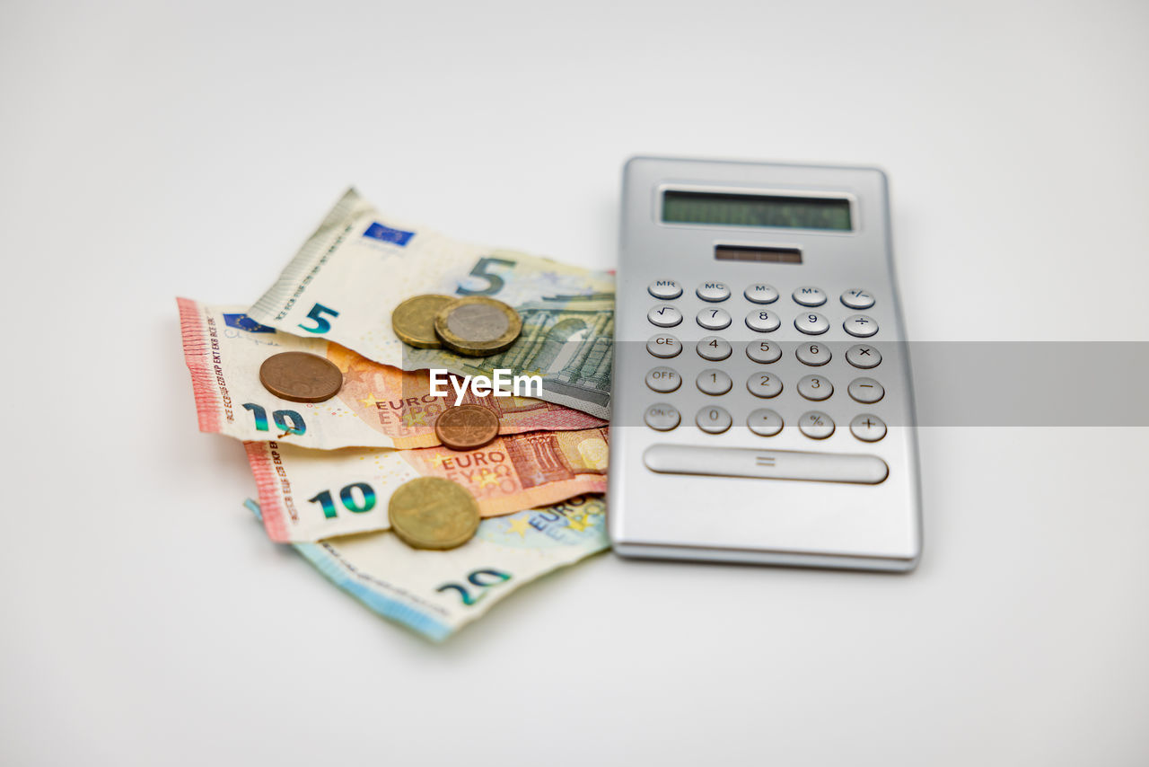 finance, cash, currency, money, paper currency, business, calculator, wealth, finance and economy, savings, studio shot, number, white background, indoors, business finance and industry, coin, banking, no people, money handling, investment, paying, home finances, office equipment