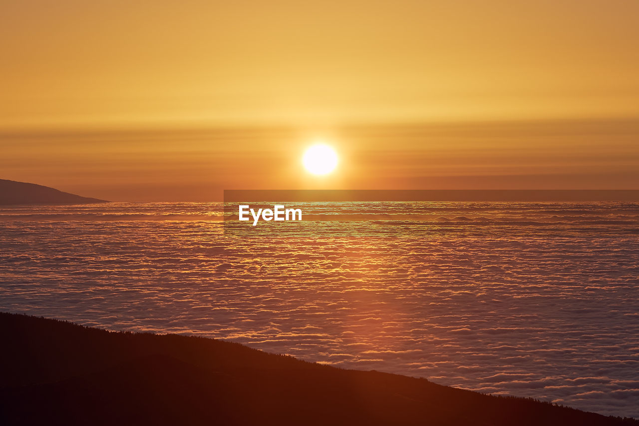 Sun above clouds. mountain landscape at golden sunset. tenerife, canary islands, spain.