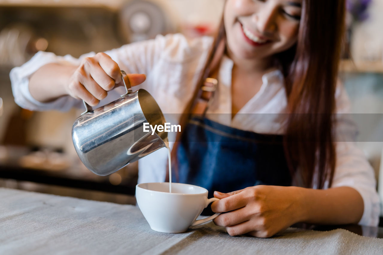 MIDSECTION OF WOMAN HAVING COFFEE