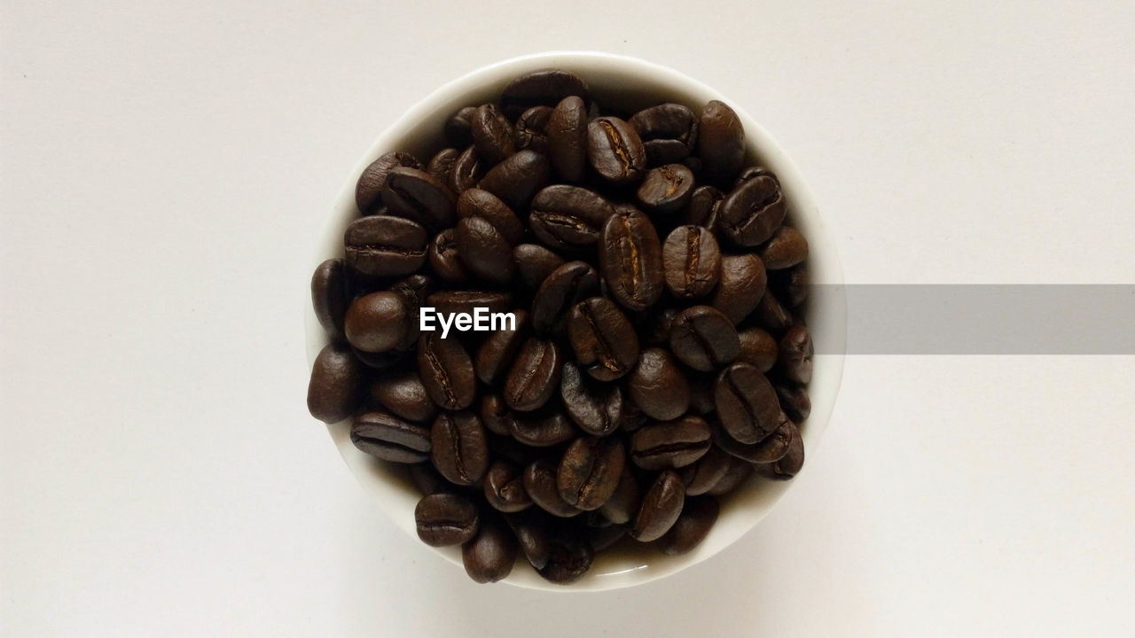 Directly above shot of coffee beans in bowl on table