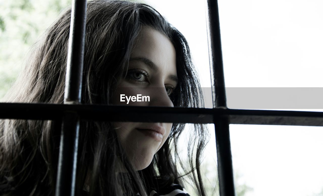 Close-up of thoughtful woman seen through window