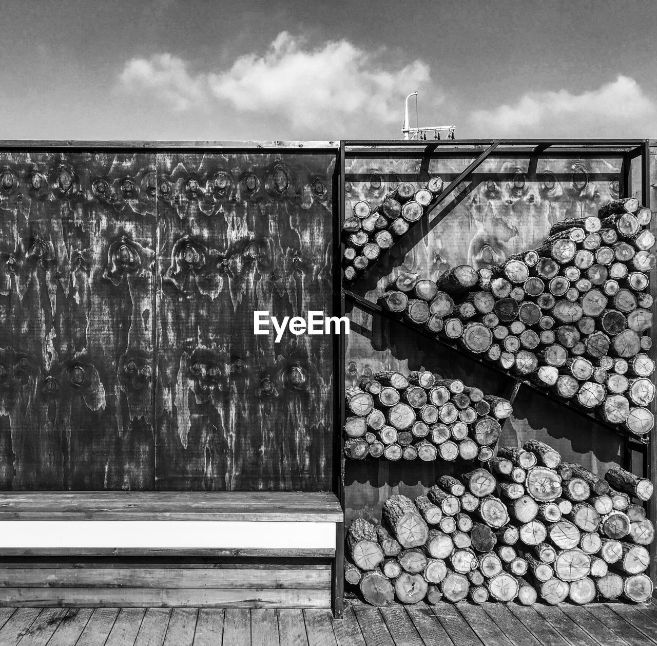 Stack of logs against sky