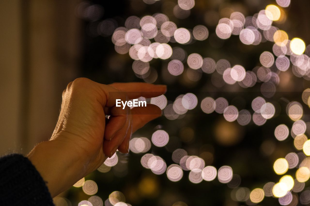 Cropped hand of woman holding illuminated lights