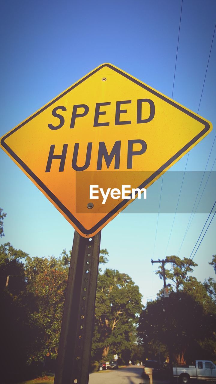 Low angle view of road sign against clear sky