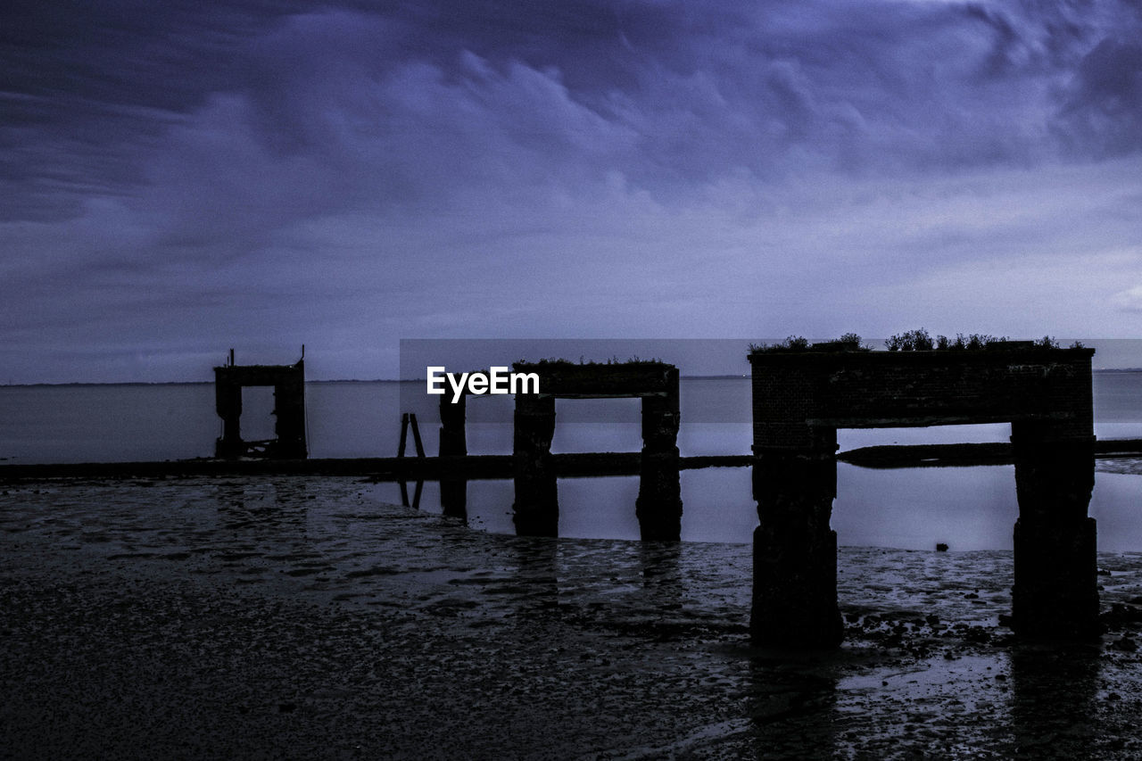 PIER AT BEACH AGAINST SKY