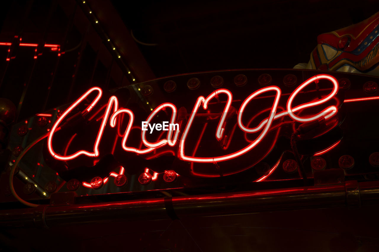 LOW ANGLE VIEW OF ILLUMINATED TEXT ON RED WALL