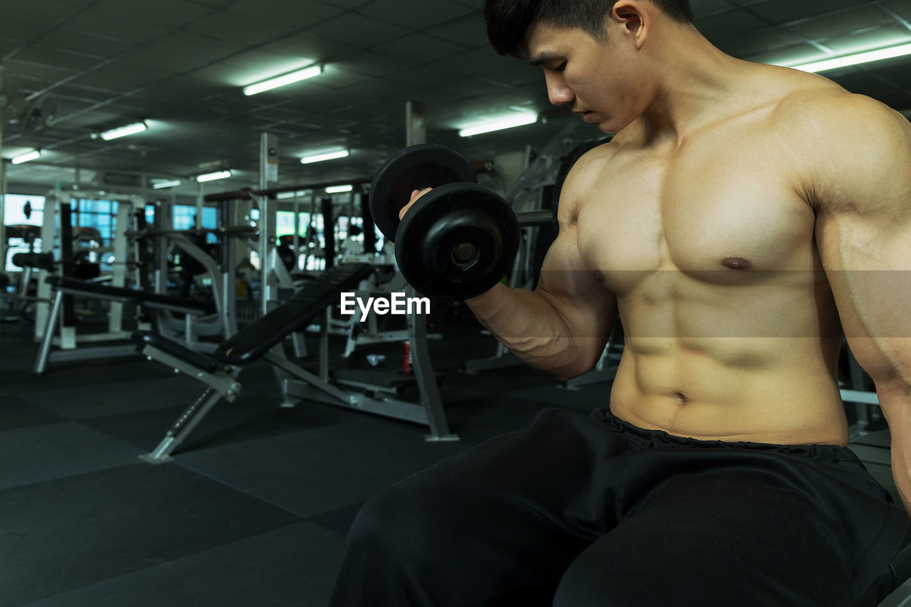 Shirtless muscular man exercising in gym