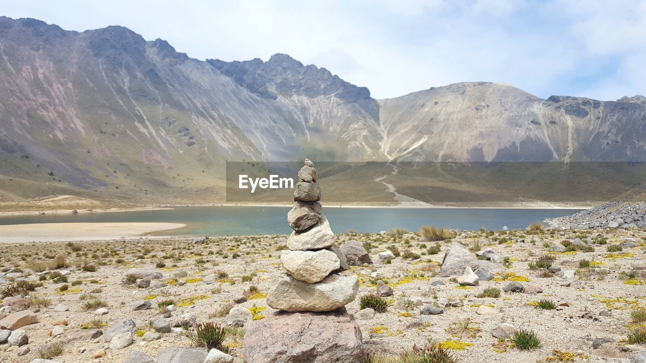 STATUE BY ROCKS AGAINST SKY