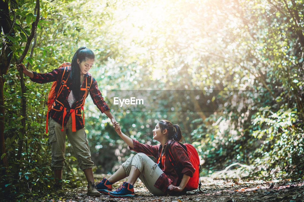 Woman assisting friend in forest