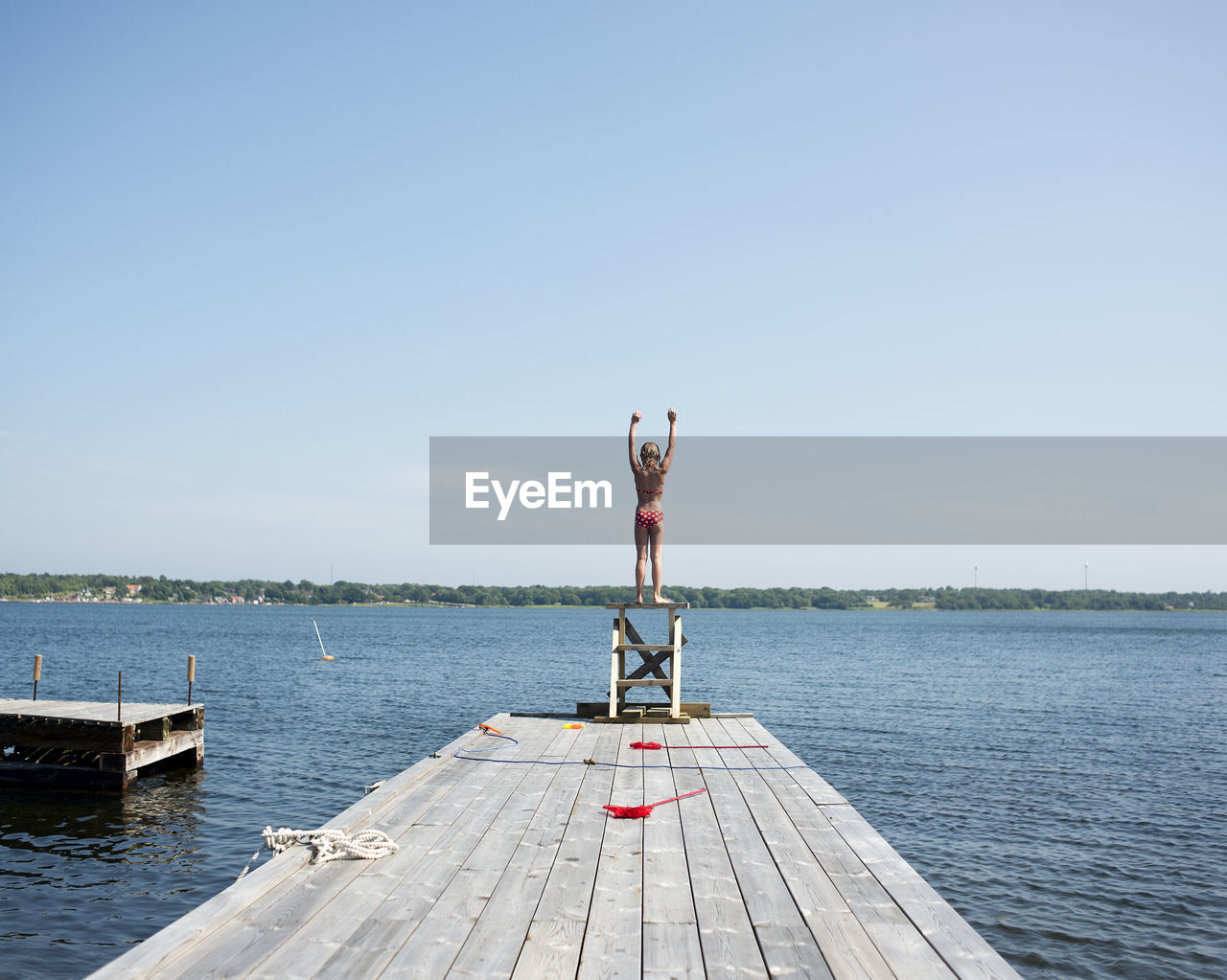 A girl diving from a jetty