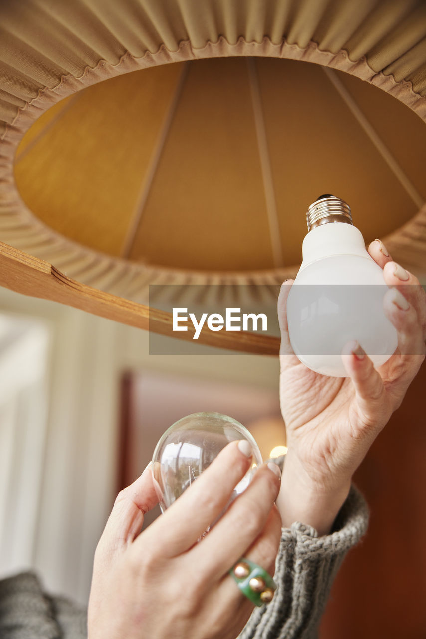 Woman's hands changing light bulb