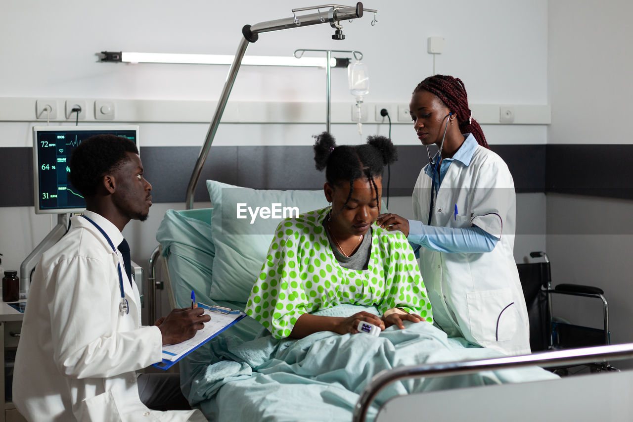 Doctors examining patient in hospital