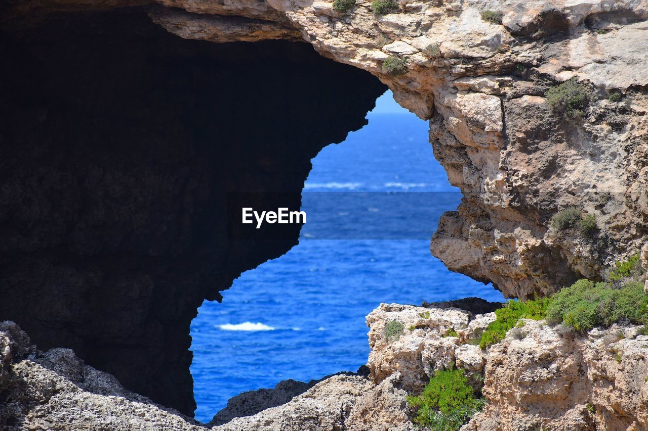 Scenic view of sea seen through cave