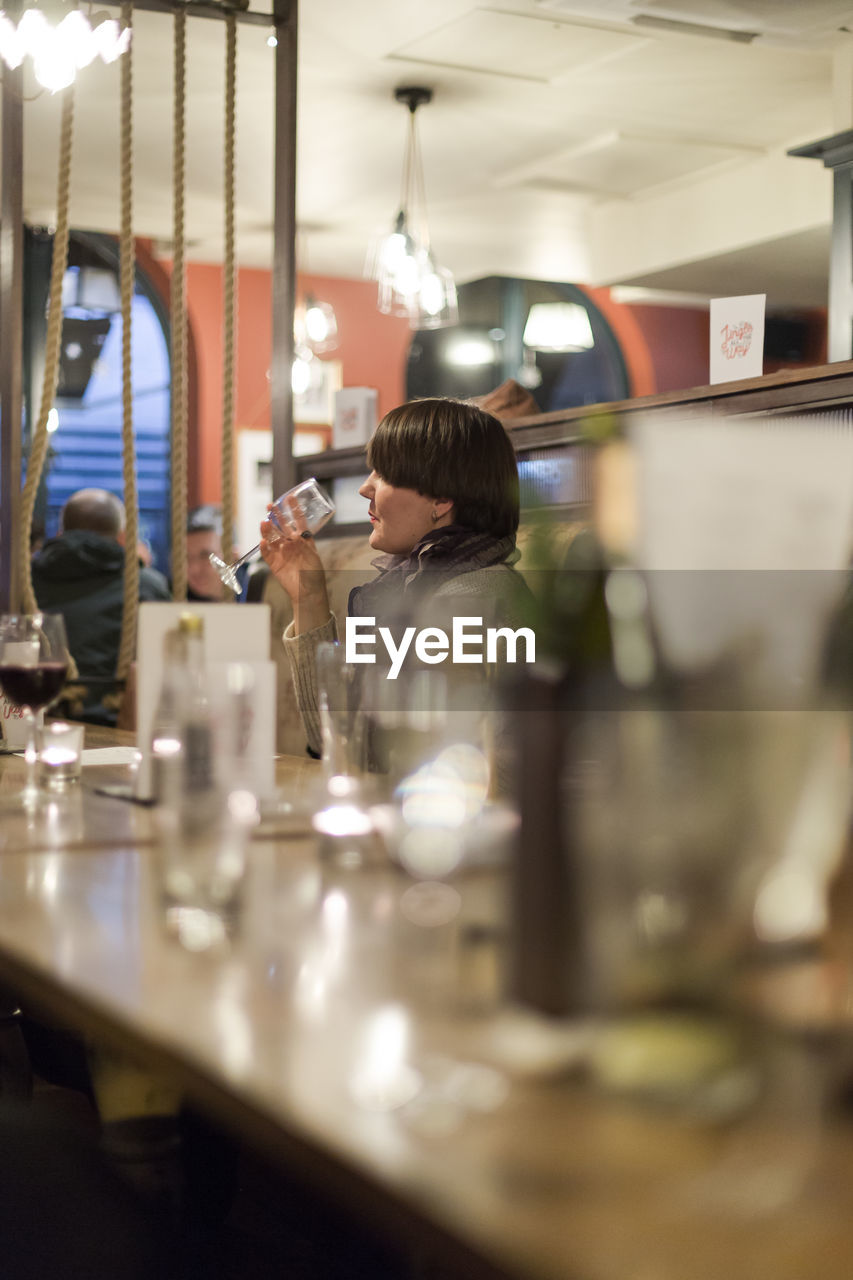 Man drinking wine at table in restaurant