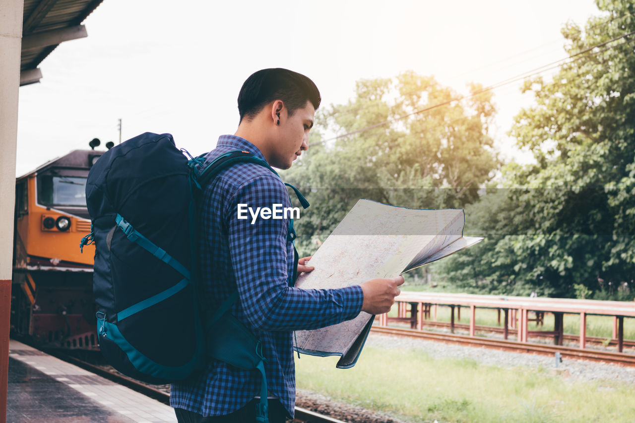 Man reading map at railroad station platform