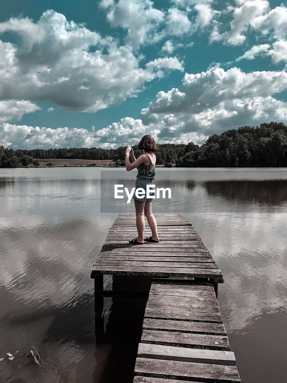 Woman standing on pier over lake